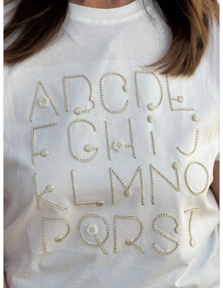 Camiseta blanca con abecedario bordado en crudo y dorado